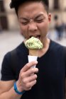 Young chinese man eating ice cream, closeup — Stock Photo