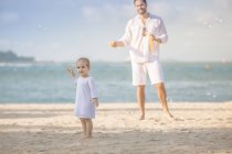 Família caucasiana feliz na praia, pai com filha se divertindo — Fotografia de Stock
