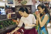 Two young asian woman shopping together in mall for food — Stock Photo