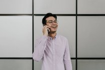 Молодий випадковий азіатський чоловік використовує смартфон — стокове фото