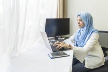 Uma jovem muçulmana que trabalha em casa
. — Fotografia de Stock