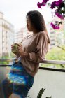 Side view of young attractive asian woman with coffee cup — Stock Photo