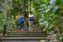 Duas mulheres caminhando para sua localização de Yoga em jardins botânicos, Singapura — Fotografia de Stock