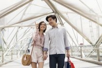 Junges asiatisches Paar geht zusammen und zeigt auf etwas — Stockfoto