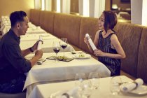 Young asian couple speaking at restaurant — Stock Photo