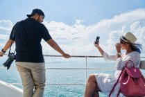 RELEASES Young couple taking photos on the deck of a ship on the way to Koh Kood, Thailand — Stock Photo