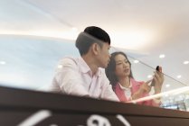 Atraente jovem asiático casal compartilhamento smartphone — Fotografia de Stock