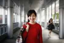 Joven hermosa mujer asiática con bolsa de compras - foto de stock