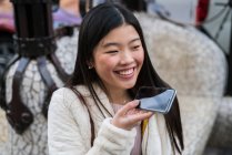 Молодая китаянка пользуется смартфоном — стоковое фото