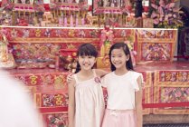 Joven feliz asiático familia, dos hermanas posando contra santuario - foto de stock