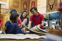 Young family browsing for carpets at Geylang Bazaar, Singapore — Stock Photo
