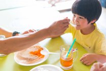 Family eating  delicacies at cafe — Stock Photo