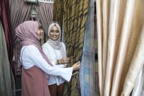 Two muslim ladies shopping for curtains. — Stock Photo