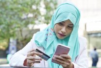 Mulher em um Hijab fazendo compras online — Fotografia de Stock