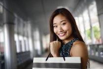 Joven asiático mujer en compras centro comercial holding bolsa - foto de stock