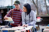 Туристична пара дивиться книги на вуличному ринку — стокове фото