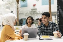Junge multikulturelle Geschäftsleute mit Kaffee und Laptop im modernen Büro — Stockfoto