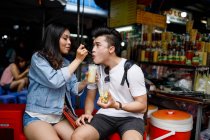 Jeune couple ayant dessert sur un étal de nourriture locale à Ho Chi Minh ville, Vietnam. — Photo de stock