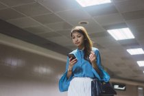 Atractivo joven asiático chica usando smartphone - foto de stock