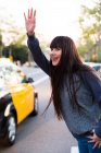 Jeune femme eurasiatique signalant un taxi à Barcelone — Photo de stock