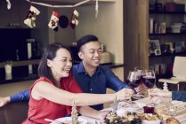 Happy asian family celebrating christmas together and cheering wine — Stock Photo