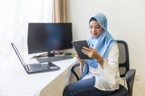 Eine junge Muslimin, die von zu Hause aus arbeitet. — Stockfoto
