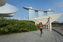 Eine junge asiatische Frau joggt in der Marina Bay von Singapore. — Stockfoto