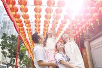 Young happy asian family in traditional buddhish shrine — Stock Photo