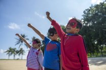 Ritratto di bambini supereroi con le mani alzate — Foto stock
