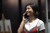 Jovem asiático mulher de negócios com smartphone no escritório moderno — Fotografia de Stock