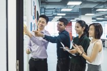 Giovani asiatici uomini d'affari al lavoro in ufficio moderno — Foto stock
