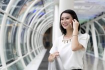 Jeune attrayant asiatique femme en utilisant smartphone — Photo de stock