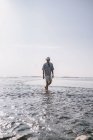 Молодой человек прогуливается по пляжу на Бали — стоковое фото
