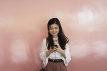 Junge beiläufige asiatische Mädchen mit Smartphone — Stockfoto