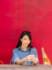 Привлекательная взрослая азиатка с помощью смартфона — стоковое фото