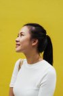 Молода приваблива азіатська жінка портрет на жовтому фоні — стокове фото