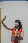 Азиатка со смартфоном делает селфи — стоковое фото