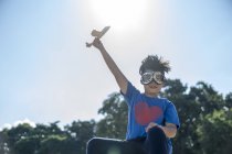 Criança super-herói brincando com um avião de brinquedo — Fotografia de Stock