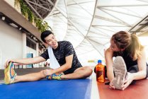 Asian couple stretching on mats — стокове фото