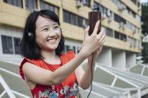 Азиатская туристка улыбается мобильно — стоковое фото