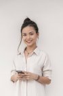 Joven asiático mujer con sonrisa usando smartphone - foto de stock