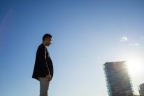Seitenansicht eines jungen asiatischen Mannes in der Stadt — Stockfoto