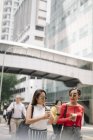 Junge asiatische Freundinnen gehen mit Kaffee — Stockfoto