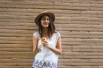 Joven mujer asiática en sombrero contra pared - foto de stock