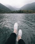 Cropped image of legs in front of lake — Stock Photo