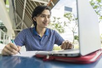 Малайська студента працюючого над школи проект на ноутбук — стокове фото