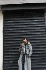 Jeune attrayant casual asiatique femme en utilisant smartphone sur la rue — Photo de stock
