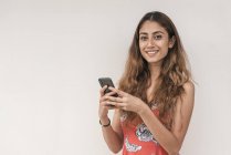 Молода красива індійська жінка використовує смартфон — стокове фото