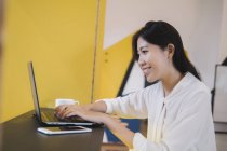 Young asian woman in creative modern office — Stock Photo