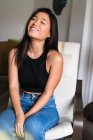 Giovane attraente asiatico donna seduta su poltrona — Foto stock